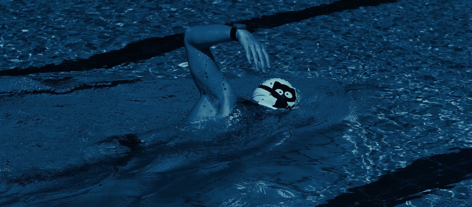 Seen from above, a swimmer doing freestyle with a watch on the wrist